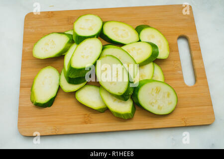 In Scheiben geschnittene Zucchini auf einem Bambus Schneidebrett Stockfoto