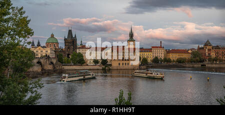 Blick auf die Altstadt über die Moldau mit dramatischen Sonnenuntergang Blick auf die historischen Gebäude in diesem beliebten Reiseziel mit tour Boote segeln. Stockfoto