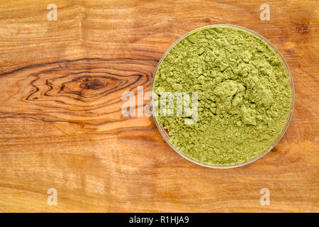 Moringa Blatt Pulver in um Schüssel gegen olivetree Holzbrett Stockfoto