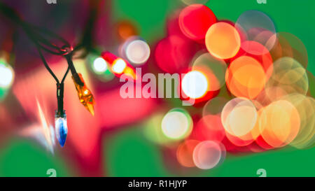 Dekorative Bunte verschwommen Lichter auf grünem Hintergrund. Weihnachten Abstrakte sanfter Beleuchtung. Bunte helle Kreise eines funkelnden Girlande Stockfoto