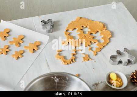 Weihnachten Lebensmittel Konzept. Rohen Teig für Kochen gingerbread man Cookies in Weihnachten auf Holztisch. Weihnachten Dessert Stockfoto