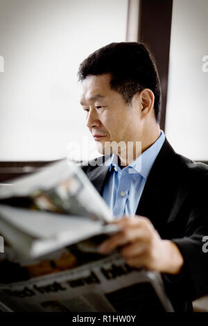 Reifen Geschäftsmann eine Zeitung lesen. Stockfoto