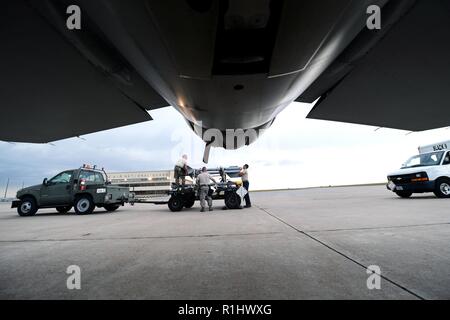 Der Bauch eines F-16 Fighting Falcon frames Flugzeuge Rüstung system Techniker an die 140 Aircraft Maintenance Squadron zugeordnet, da sie eine 141 Trailer für Tow an Buckley Air Force Base, Colorado, Sept. 19, 2018 vorbereiten. Ob ein Avionik Spezialist, Crew Chief oder Hydraulik Spezialist, der Wartung Flieger sind verantwortlich für die Aufrechterhaltung der Mission - den Status "Bereit" von über 20 F-16. Stockfoto