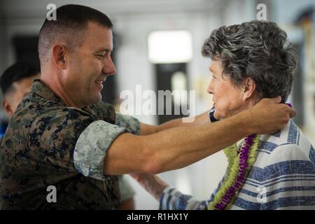 Us Marine Corps Oberstleutnant Brian Clifton, Links, kommandierender Offizier, Marine Medium Tiltrotor Squadron (VMM) 363, präsentiert Cynthia Thielen, rechts, Hawaii State Vertreter, mit einem lei während Hangar Widmung der VMM 363 Zeremonie, Marine Corps Air Station Kaneohe Bay, Marine Corps Base Hawaii, Sept. 21, 2018. Die Widmung Zeremonie feierten die Ankunft der Marines mit VMM 363 und alle, die in den Bau des Hangars unterstützt. Die Ankunft einer zweiten B MV-22 Osprey Geschwader deutlich erhöht Marine Flugzeuge Gruppe 24 die Fähigkeit der lokalen Notfällen innerhalb von Hawaii zu reagieren ein Stockfoto