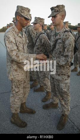 Rekrutieren James McConnell, mit Lima Company, 3 Recruit Training Bataillon, erhält er den Adler, Globus und Anker nach Abschluss der Tiegel, auf Marine Corps Recruit Depot Parris Island, S.C., Sept. 22, 2018. Der Tiegel ist ein 54-Stunden Höhepunkt, die Rekruten zu arbeiten als Team die Herausforderungen der Titel des United States Marine zu erwerben, zu überwinden. Stockfoto