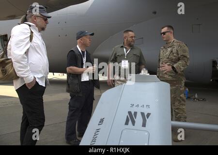 Cpl. Jarrod Saxton, ein unbemanntes System Operator, D. Co 152 Brigade Ingenieur Bataillon zugeordnet, erklärt die Funktionen der RQ-7 Shadow zu den Einheimischen in Waterkloof Air Force Base, Südafrika während der Afrikanische Luft-/Raumfahrt- und Verteidigungsindustrie Ausstellung, Sept. 20, 2018. Saxton ist Teil eines Kontingentes von New York Luft und Armee Wachmännern Streitkräfte ihren Stand auf der Messe vertreten. Stockfoto