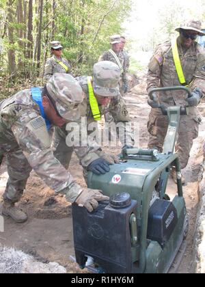 Spc. Darius Davis, 161 Techniker Support Unternehmen, 27 Engineer Battalion (Combat) (aus der Luft), schiebt eine hand Stampfer mit Hilfe von anderen Fallschirmjäger während der Reparatur ein Ausgewaschen Straße bei militärischen Ocean Terminal Sunny Punkt, N.C., Sept. 22. Die Einheit, zusammen mit Personal für die fünf Bezirke von der US-Armee Korps der Ingenieure, ist die Unterstützung bei der Wiederherstellung der Installation nach Hurrikan Florenz. Stockfoto