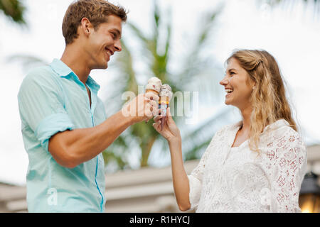 Lächelnden jungen Paare Toasten mit ihren Eistüten. Stockfoto
