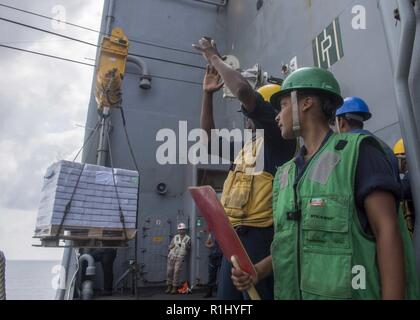 Golf von Aden (Sept. 21, 2018) der Bootsmann Mate 2. Klasse Leroi Ellison, Links, und Seaman Apprentice Mikenzi Walker direkte Ladung auf Whidbey Island-Klasse dock Landung Schiff USS Rushmore (LSD 47), während in einer Auffüllung teilnehmenden-auf-See während einer planmäßigen Einsatz der Essex Amphibious Ready Group (ARG) und 13th Marine Expeditionary Unit (MEU). Das Essex ARG/13 MEU ist tödlich, flexibel, und anhaltende Navy-Marine Corps Team in die USA 5 Flotte Bereich der Maßnahmen zur Unterstützung der Marine im Einsatz für die Stabilität und Sicherheit in der Region zu gewährleisten, angeschlossen sein. Stockfoto