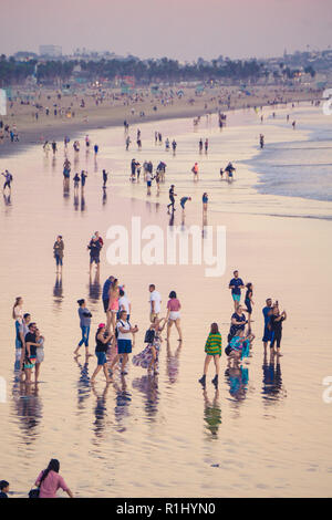 Massen von Menschen auf dem Santa Monica Strand bei Sonnenuntergang Stockfoto