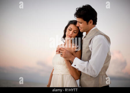 Portrait einer jungen jungvermählte Paar zärtlich umarmt nach ihrer Hochzeit. Stockfoto