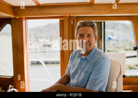 Reifer Mann in einem Boot suchen Inhalt sitzen Stockfoto