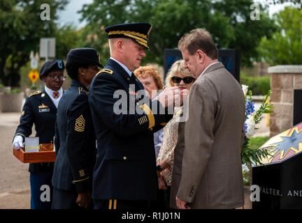 Brig. Gen. Darren L. Werner, Kommandierender General des 13. WSA, Stifte die Gold Star Ehrennadel auf Greg Kieschnick, Sohn von Kaplan Alton Raymond Kieschnick, der 1975 starb, während der Rückkehr von einer Schulungsveranstaltung in Fort Hood, während des 13 ESC Memorial rededication Zeremonie an Sept. 21, 2018 in Fort Hood, Texas. Die kieschnick Familie wurde offiziell als Gold Star Familie während der Zeremonie anerkannt. Stockfoto