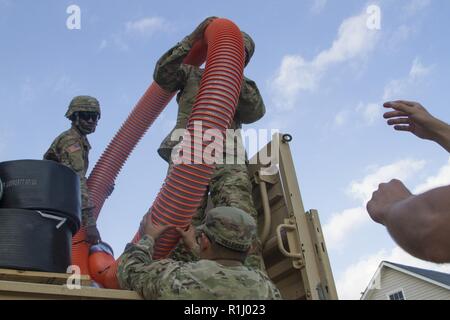 US-Armee Soldaten mit der Sitz und die Hauptverwaltung Company, 236th Engineer Brigade und das Bataillon der 74. Composite Truck Company, Luftlandedivision, Schläuche für Wasser Pumpen entladen nach dem Hurrikan Florenz in der Nähe von Morehead City, North Carolina an Sept. 20, 2018. Mehrere Armee Komponenten kamen zusammen, lokale und staatliche Anstrengungen, das Leben der Zivilisten wiederherzustellen, nachdem der Hurrikan zu unterstützen. Stockfoto