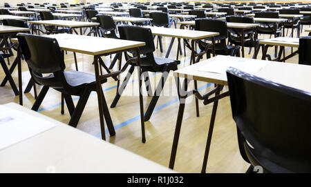Anzeigen von großen Untersuchungsraum Halle und Prüfung Schreibtische Tische gesäumt in Reihen bereit für Studierende an einer High School zu kommen und ihre Prüfungen Prüfungen Papier sitzen Stockfoto