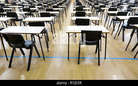 Anzeigen von großen Untersuchungsraum Halle und Prüfung Schreibtische Tische gesäumt in Reihen bereit für Studierende an einer High School zu kommen und ihre Prüfungen Prüfungen Papier sitzen Stockfoto