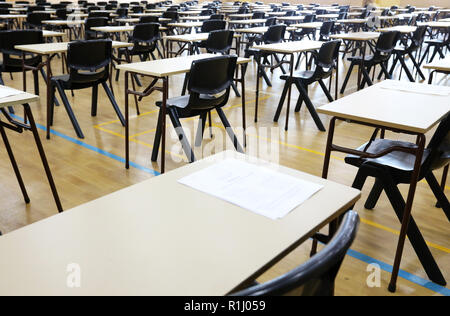 Anzeigen von großen Untersuchungsraum Halle und Prüfung Schreibtische Tische gesäumt in Reihen bereit für Studierende an einer High School zu kommen und ihre Prüfungen Prüfungen Papier sitzen Stockfoto