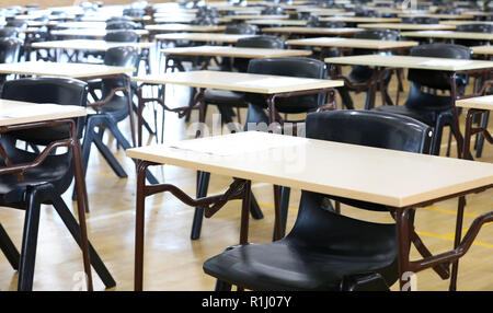 Anzeigen von großen Untersuchungsraum Halle und Prüfung Schreibtische Tische gesäumt in Reihen bereit für Studierende an einer High School zu kommen und ihre Prüfungen Prüfungen Papier sitzen Stockfoto