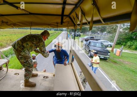 Us-Armee Brig. Gen. Jeff Jones, die South Carolina National Guard Assistant Adjutant General für Armee, unterstützt von Soldaten aus dem 1053Rd Transport Unternehmen, wie sie Verkehr Mitglieder der Gemeinschaft in den überschwemmten Gebieten kritische Elemente aus ihren Häusern als das Wasser abrufen weiterhin in ihrer Nachbarschaft zu steigen, mit hohem Wasser Fahrzeuge, in der Stadt von Bucksport, S.C., Sept. 24, 2018. Lokale Bürger werden davor gewarnt, sich "umzuwenden, nicht ertrinken", wenn Sie über Kegel, Hindernisse kommen oder überfluteten Straßen bei Reisen in betroffene Gebiete von S.C. Vermögenswerte von vielen Agenturen und militärische Organisationen sind Stockfoto