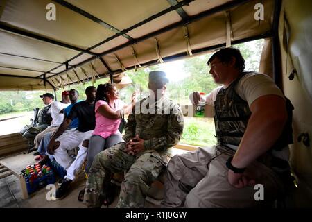 Us-Armee Brig. Gen. Jeff Jones, die South Carolina National Guard Assistant Adjutant General für Armee, unterstützt von Soldaten aus dem 1053Rd Transport Unternehmen, wie sie Verkehr Mitglieder der Gemeinschaft in den überschwemmten Gebieten kritische Elemente aus ihren Häusern als das Wasser abrufen weiterhin in ihrer Nachbarschaft zu steigen, mit hohem Wasser Fahrzeuge, in der Stadt von Bucksport, S.C., Sept. 24, 2018. Lokale Bürger werden davor gewarnt, sich "umzuwenden, nicht ertrinken", wenn Sie über Kegel, Hindernisse kommen oder überfluteten Straßen bei Reisen in betroffene Gebiete von S.C. Vermögenswerte von vielen Agenturen und militärische Organisationen sind Stockfoto