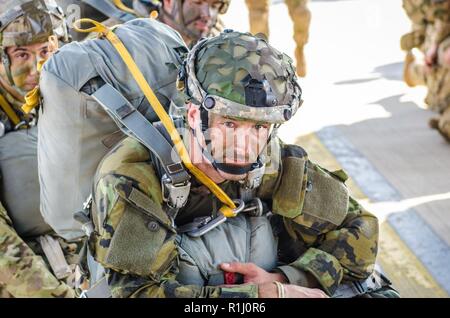 Eine Italienische Fallschirmjäger sitzt und wartet eine US Air Force C-130 an Bord während Sabre Kreuzung 18, an der Air Base Ramstein, Deutschland, Sept. 19, 2018. Sabre Kreuzung 18 ist der US-Armee 173rd Airborne Brigade Combat Training Center Zertifizierung statt auf der Grafenwöhr und Hohenfels Ausbildungsbereichen. Die US-Armee Europa - Regie konzipiert ist die Bereitschaft der Feuerwehr unified Land arbeiten in einer gemeinsamen, kombinierten Umwelt zu führen und die Interoperabilität mit den teilnehmenden Verbündete und Partner Nationen zu fördern zu bewerten. Sabre Kreuzung 18 umfasst nahezu 5.500 Pa Stockfoto