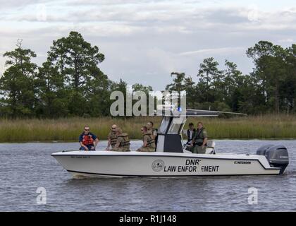 Südcarolina nationale Schutz Soldaten, Küstenwache und Abteilung der natürlichen Ressourcen der Strafverfolgungsbehörden escort float Brücken Transport Emergency Response Fahrzeuge über Wasserstraßen in Georgetown, South Carolina, Sept. 24, 2018. Rund 2.900 Soldaten und Piloten haben eine Partnerschaft zur Unterstützung der zivilen Behörden mobilisiert worden, die Bürgerinnen und Bürger von South Carolina in den Nachwehen des tropischen Sturms Florenz zu sichern. Stockfoto