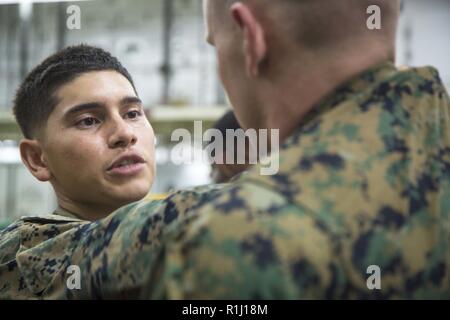 Golf von Aden-Marine Sgt. Nicolas Herrera, ein Radio Techniker mit Marine Medium Tiltrotor Squadron 166 verstärkt, 13 Marine Expeditionary Unit (MEU), geht durch die Schritte der vorderen Technik choke beim Marine Corps Martial Arts Program Training an Bord der Wasp-Klasse amphibisches Schiff USS Essex (LL 2), Sept. 25, 2018. Der Essex ist das Flaggschiff der Essex Amphibious Ready Gruppe und mit dem begonnen 13. MEU, ist in die USA 5 Flotte Bereich der Maßnahmen zur Unterstützung der Marine im Einsatz für die Stabilität und Sicherheit in der Region zu gewährleisten, angeschlossen sein. Stockfoto