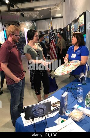 WALLOPS ISLAND, Va. (Bis 30. 22, 2018) Laura Busch, rechts, eine natürliche Ressourcen Spezialist bei der US-Flotte Kräfte Befehl, erklärt betrieblicher Abfälle aus der Verarbeitung zu Besucher bei "Verwalter der U.S. Navy auf das Meer: die Verteidigung der Freiheit, den Schutz der Umwelt" Ausstellung während der NASA 60. Jahrestag Feier bei der NASA Wallops Flight Facility Visitor Center statt. Die Marine setzt alle Mittel zur Verfügung, um die potenziellen Umweltauswirkungen unserer Tätigkeiten ohne Gefährdung der Sicherheit unserer Matrosen oder unsere Marine Bereitschaft mission Beeinträchtigung zu mildern. Stockfoto