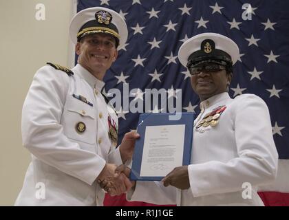 NORFOLK, Virginia (Sept. 21, 2018) Chief Electrician's Mate Charlene Parker, von Manning, Südcarolina, USS Gerald R. Ford's (CVN 78) Engineering Abteilung zugewiesen, erhält einen Brief der Wertschätzung von ehemaligen Präsidenten Barack Obama, präsentiert von Kapitän Brent Gaut, Executive Ford's Officer, bei ihrem Eintritt in den Ruhestand Zeremonie an Commander, Naval Surface Force Atlantik. Parker zieht sich von der Marine nach 24 Jahren Service. Stockfoto