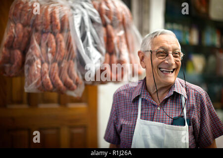 Portrait von fröhlichen älteren Metzger bei der Arbeit. Stockfoto