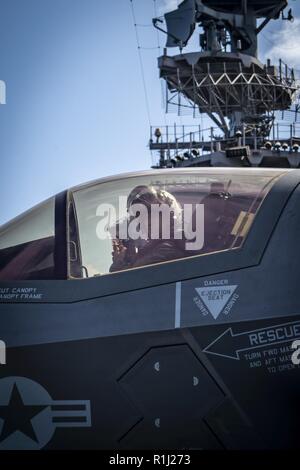 Golf von Aden (Sept. 22, 2018) - Marine Corps Maj. Alexander Mellman, zugeordnet zu den "Avengers" der Marine Fighter Attack Squadron (Vmfa) 211, bereitet sich auf den Flugbetrieb im Cockpit einer F-35 B Blitz II während einer planmäßigen Einsatz von Essex Amphibious Ready Group (ARG) und 13th Marine Expeditionary Unit (MEU). Das Essex ARG und 13. MEU ist der erste US-Marine/Marine Corps Team USA 5 Flotte Bereich der Operationen mit der transformational warfighting Fähigkeiten der F-35B Blitz II bereitstellen, so dass es ein tödlicher, flexible und beständige Kraft, zu einem führenden Stockfoto