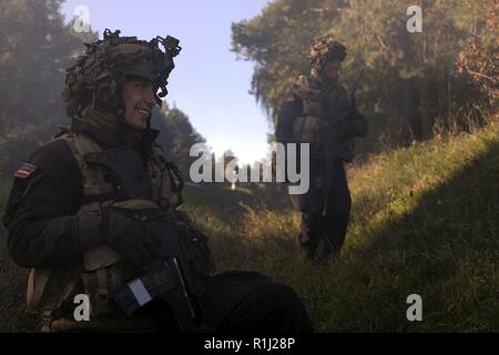 Von links, Pvt. Markuss Krallišs und Pfc. Edgar Zvejnieks mit der lettischen Armee und ein Teil der gegnerischen Streitmacht in einer Beobachtung pointduring Übung Sabre Kreuzung 18 in Hohenfels Training Area, Germany, Sept. 25, 2018. Sabre Kreuzung 18 Ist der 173Rd Infantry Brigade Combat Team (Airborne) Training Center Zertifizierung bei den Grafenwöhr und Hohenfels Ausbildung Bereiche, Sept. 4 - 1. Oktober 2018 statt. Die US-Army Europe - Geleitete Übung sollen die Bereitschaft der Feuerwehr unified Land arbeiten in einer gemeinsamen, kombinierten Umgebung zu leiten und zu int fördern zu bewerten Stockfoto