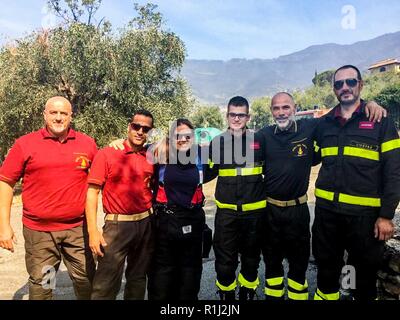 Camp Darby Feuerwehrmänner posieren für ein Gruppenfoto mit der örtlichen Feuerwehr Beamte. Die Feuerwehr Wasser italienische Brandbekämpfung Fahrzeuge erreicht werden können Brände in gebirgigem Gelände während einer großen Waldbrand in der Nähe von Pisa, Sept. 25. Us-Armee Feuerwehrmänner Unterstützung mit Hunderten von italienischen Feuerwehrleute bei der Bekämpfung der Wildfire, die in den Hügeln über der Stadt Pisa während der späten Abend brach, Sept. 24. Stockfoto