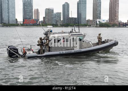 NEW YORK - Coast Guard Besatzungsmitglieder an Bord eines 33-Fuß-Special Purpose Handwerk - Strafverfolgung Boot von Coast Guard Maritime Security Response Team (MSRT) transport Personal während einer Messe Unfallversicherung Bohrer auf dem East River außerhalb der Gebäude der Vereinten Nationen, Sept. 21, 2018 durchgeführt. Die Küstenwache zusammen mit mehreren Agenturen, die Unterstützung für die Sicherheit im Seeverkehr und Sicherheit während des Landes größte nationale spezielle Security Event (nsse). Stockfoto