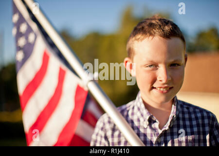 Porträt eines Jungen Holding eine amerikanische Flagge. Stockfoto