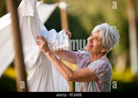 Junge spielerisch Rollen im Gras. Stockfoto