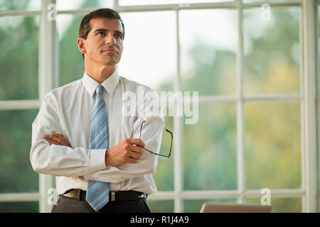 Mitte der erwachsenen Unternehmer Stehen mit verschränkten Armen. Stockfoto