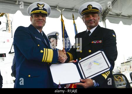 U.S. Coast Guard Vice Adm. Michael McAllister, Stellvertretender Kommandant für die Mission unterstützen, und ukrainischen Adm. Ihor Voronchenko, Seestreitkräfte der Ukraine Commander, Hände schütteln nach Abschluss ein Zertifikat der Implementierung für die Übertragung von zwei 110-Fuß-Fräser für die ukrainische Regierung auf der Coast Guard Yard in Baltimore, Sept. 27, 2018. Die Messer waren Insel klasse Patrouillenboote, die wertvolle Vermögenswerte haben der US-Küstenwache seit Jahrzehnten. Stockfoto