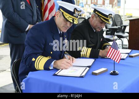 U.S. Coast Guard Vice Adm. Michael McAllister, Stellvertretender Kommandant für die Mission unterstützen, und ukrainischen Adm. Ihor Voronchenko, Seestreitkräfte der Ukraine Commander, unterzeichnen ein Zertifikat der Implementierung für die Übertragung von zwei 110-Fuß-Fräser für die ukrainische Regierung auf der Coast Guard Yard in Baltimore, Sept. 27, 2018. Die Messer waren Insel klasse Patrouillenboote, die wertvolle Vermögenswerte haben der US-Küstenwache seit Jahrzehnten. Stockfoto