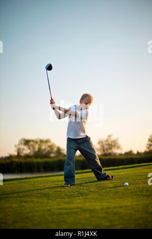 Junge Schwingen einer Gold Club auf einem Golfplatz. Stockfoto