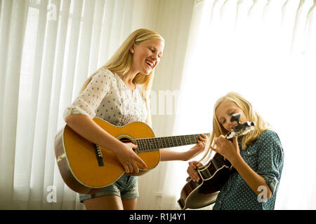 Happy Jugendmädchen Gitarre spielen zusammen. Stockfoto