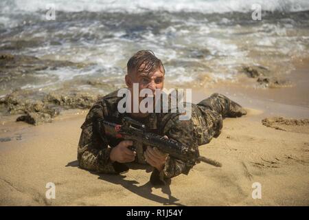 Us Marine Corps Cpl. Ethan Wetzel, Studentin an der Corporal Kurs mit Sitz Bataillon, Marine Corps Base Hawaii, schreit 'Kontakt' zu seinen Kommilitonen während einer Strand Hinterhalt Szenario als Teil einer End-of-the-Kurs kleine Einheit Führung Bewertung (SULE), Sept. 26, 2018. Die Mission der SULE ist Marines zu trainieren wie ihre Gruppe während der Konfrontation zu führen und unter Stress während der verschiedenen Szenarien. Stockfoto