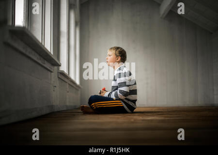 Junge nachdenklich aus dem Fenster. Stockfoto