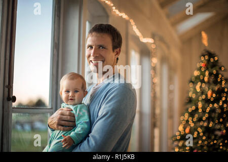 Porträt eines lächelnden Vater seine Tochter Holding. Stockfoto