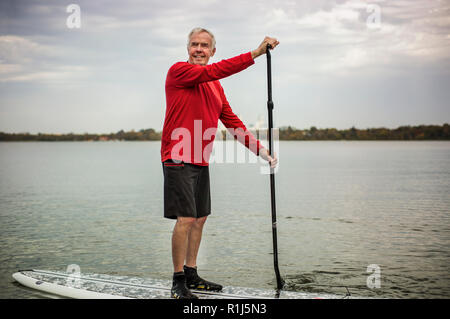 Älterer mann Paddle Boarding. Stockfoto
