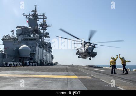 Arabische Meer (Okt. 2010) 4, 2018) - Ein CH-53E Super Stallion Hubschrauber, die an der "Elche" der Marine Medium Tiltrotor Squadron (VMM) 166 (verstärkt), zieht aus der Flight Deck von Wasp-Klasse amphibisches Schiff USS Essex (LL 2), die während einer planmäßigen Einsatz von Essex Amphibious Ready Group (ARG) und 13th Marine Expeditionary Unit (MEU). Das Essex ARG/13 MEU ist eine tödliche, flexibel, und anhaltende Navy-Marine Corps Team in die USA 5 Flotte Bereich der Maßnahmen zur Unterstützung der Marine im Einsatz für die Stabilität und Sicherheit in der Region zu gewährleisten, Anschließen Stockfoto