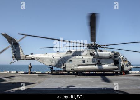 Arabische Meer (Okt. 2010) 4, 2018) - Ein CH-53E Super Stallion Hubschrauber, die an der "Elche" der Marine Medium Tiltrotor Squadron (VMM) 166 (verstärkt), bereitet sich auf den Flugbetrieb auf dem Flugdeck der Wasp-Klasse amphibisches Schiff USS Essex (LL 2), die während einer planmäßigen Einsatz von Essex Amphibious Ready Group (ARG) und 13th Marine Expeditionary Unit (MEU). Das Essex ARG/13 MEU ist eine tödliche, flexibel, und anhaltende Navy-Marine Corps Team in die USA 5 Flotte Bereich der Maßnahmen zur Unterstützung der Marine im Einsatz für die Stabilität und Sicherheit in der Zentrale zu gewährleisten Stockfoto