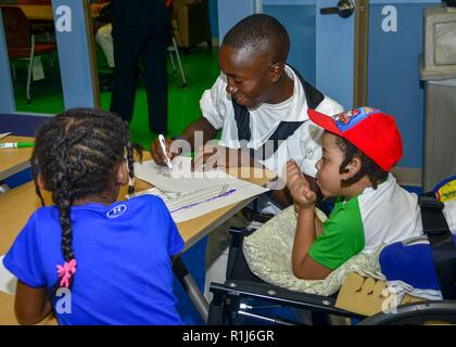 BALTIMORE, MD (Okt. 2010) 4, 2018) Seaman Jason Heder Petitfrere, von Carrefour, Haiti, auf USS Verfassung zugewiesen ist, interagiert mit Kindern am Mt. Washington pädiatrische Krankenhaus während Maryland Flotte Woche und Air Show Baltimore, 4. Oktober 2018. Maryland Flotte Woche und Air Show ist Baltimore Baltimore's Feier der sea Services und bietet die Möglichkeit für die Bürgerinnen und Bürger von Baltimore zu treffen Segler, Marines, und an der Küste der Scots Guards, sowie Sie aus erster Hand die neuesten Funktionen der heutigen Maritime Services. Stockfoto