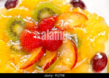 Kiwi, Erdbeeren, Äpfel, Trauben, Ananas und orange mit Gelatine Stockfoto