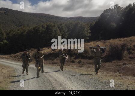 Neuseeland Armee Lance Cpl. Jonathan Sorenson und US-Marines Verhalten eine Bewegung während der Übung Joint Assault Signale Firma Schwarz, Waiouru, Neuseeland, Oktober 5, 2018. Sorenson, ein Eingeborener von Christchurch, Neuseeland, ist ein Abschnitt, der zweite mit 2 Engineer Regiment, 3 Staffel, 1 NZ Brigade. Die Marines sind Funker und Beobachter mit 1St Brigade, 5 Air Naval Geschützfeuer Liaison Firma, III Marine Expeditionary Force Information Group, III MEF. Während des Trainings, gegensätzliche Kräfte bestehend aus Komponenten der Neuseeländischen Armee und 5 ANGLICO Stockfoto